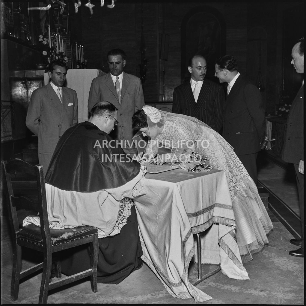 La sposa del dottor Della Croce firma il registro parrocchiale al termine del matrimonio celebrato nella Chiesa di San Protaso in via Osoppo a Milano<br>217472