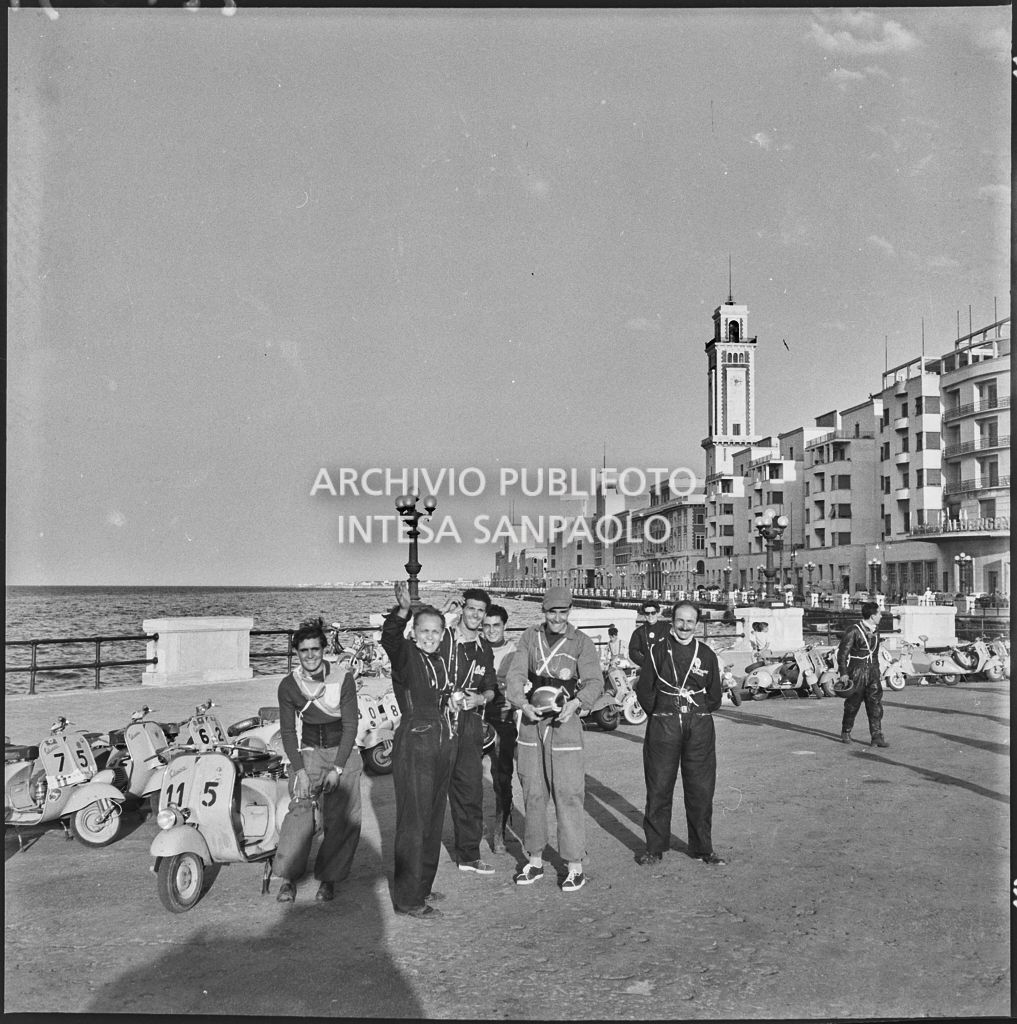 Alcuni partecipanti del 2° Giro Vespistico dei Tre Mari durante un momento di pausa sul lungomare<br>221631