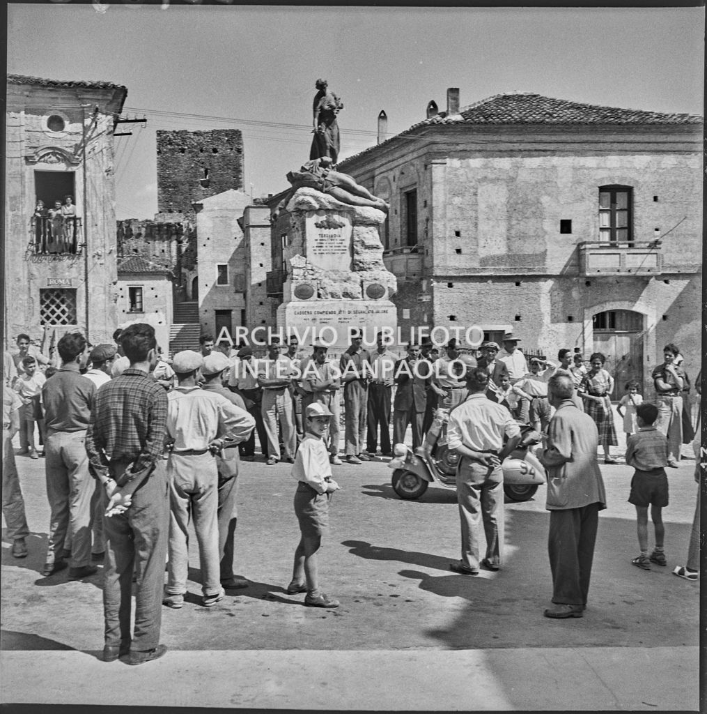 Passaggio di un concorrente del 2° Giro Vespistico dei Tre Mari in una piazza gremita di gente<br>221650
