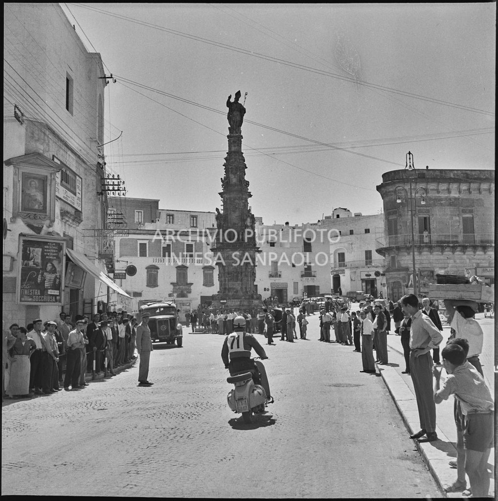 Un concorrente del 2° Giro Vespistico dei Tre Mari davanti alla Colonna di Sant'Oronzo in piazza della Libertà ad Ostuni<br>221677