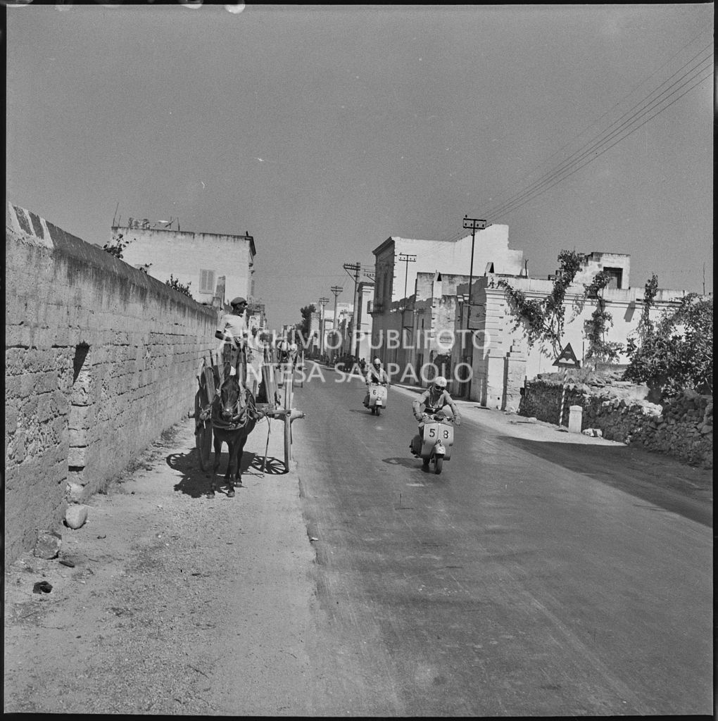 Due concorrenti del 2° Giro Vespistico dei Tre Mari affiancano un carro trainato da un asino durante il percorso<br>221682