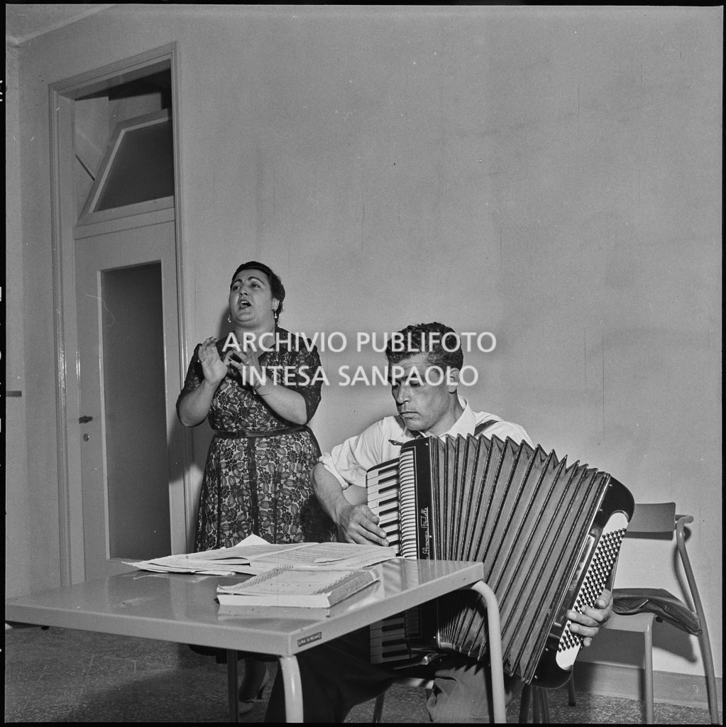 Una donna canta accompagnata dalla fisarmonica durante la festa organizzata nella sede dell'AVIS di Milano in via Bassini<br>221806
