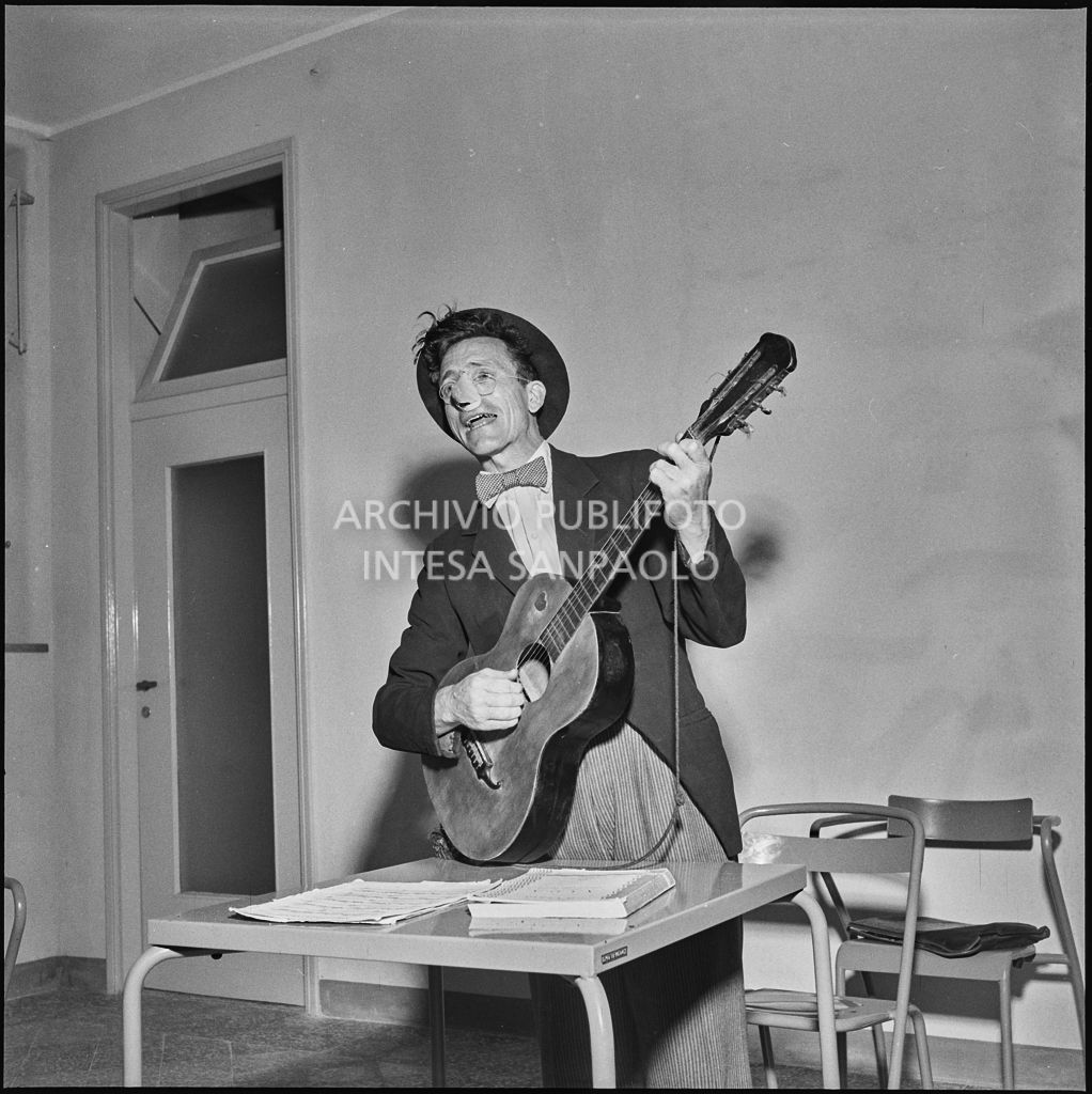 Un uomo canta accompagnato dalla chitarra durante la festa organizzata nella sede dell'AVIS di Milano in via Bassini<br>221812