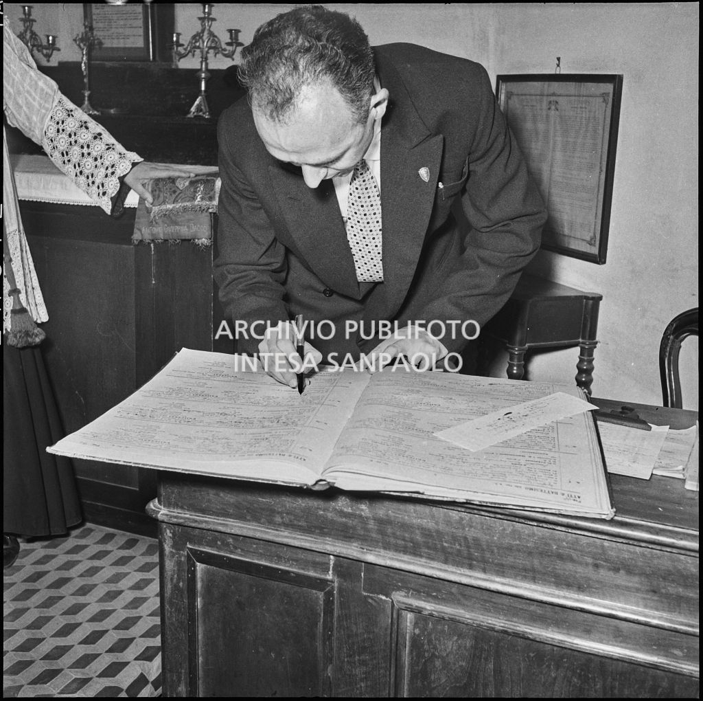 Il signor Bernardi firma il registro parrocchiale al termine del battesimo della figlia<br>221823