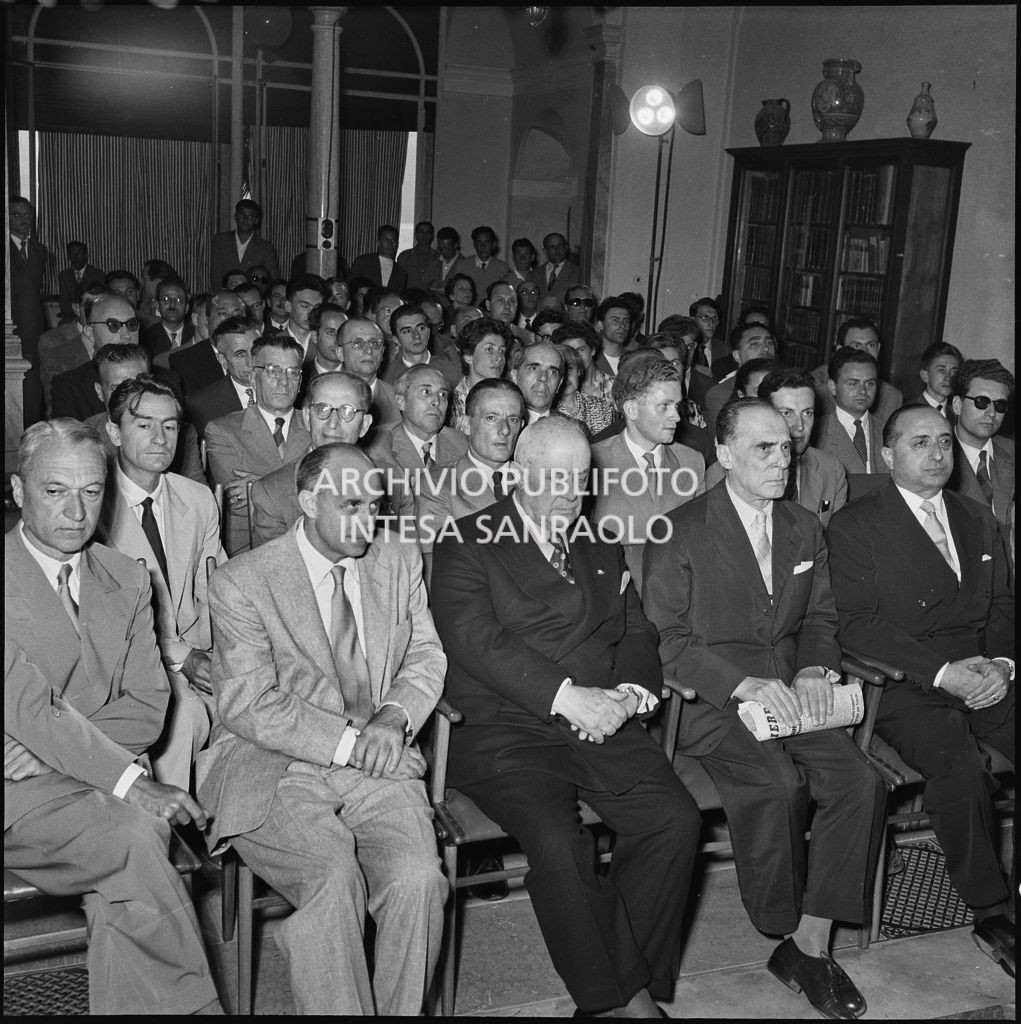 Pubblico all'inaugurazione della seconda edizione del Corso Internazionale di Fisica svoltosi a Villa Monastero a Varenna. Visibili in prima fila il professor Bernardo Rossi (primo da sinistra) e il professor Enrico Fermi (secondo da sinistra) e Eugenio Rossano (terzo da sinistra), in seconda fila il professor Gilberto Bernardini (primo da sinistra)<br>221850