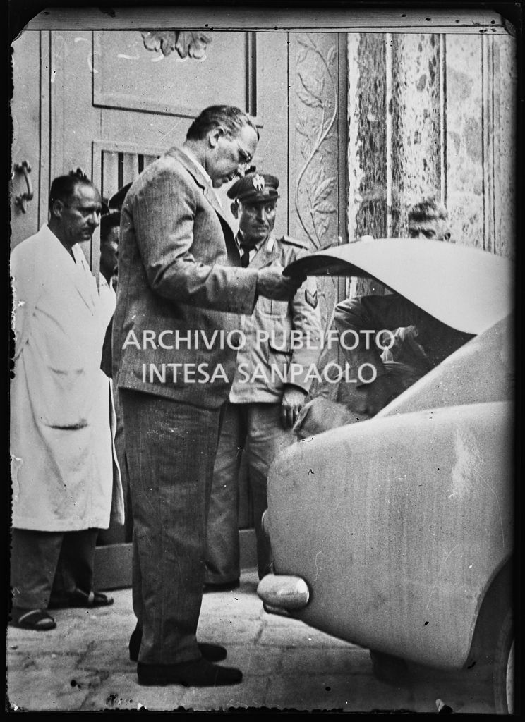 Carlo Caroselli, fratello della contessa Pia Bellentani, carica le valige sulla macchina all'entrata del manicomio criminale di Aversa<br>222259