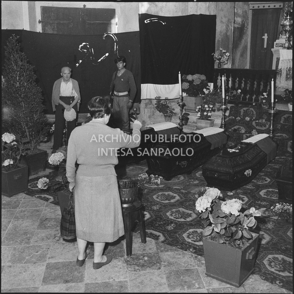 Una donna benedice le bare dei cinque marinai della Brigata San Marco nella chiesa della Madonna del Pezzo, morti per lo scoppio di un mortaio durante un'esercitazione nei pressi di Levico<br>222272