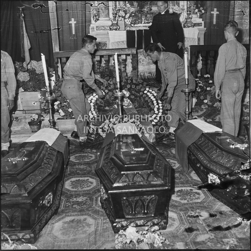 Due marinai della Brigata San Marco posizionano una ghirlanda di fiori dietro alle bare dei cinque commilitoni nella chiesa della Madonna del Pezzo, morti per lo scoppio di un mortaio durante un'esercitazione nei pressi di Levico<br>222333