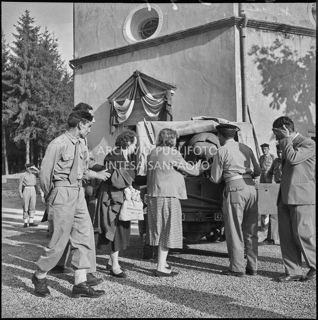 Alcune persone salgono su un fuoristrada militare davanti alla chiesa della Madonna del Pezzo, dopo aver fatto visita ai cinque marinai della Brigata San Marco vittime dello scoppio di un mortaio durante un'esercitazione nei pressi di Levico<br>222347