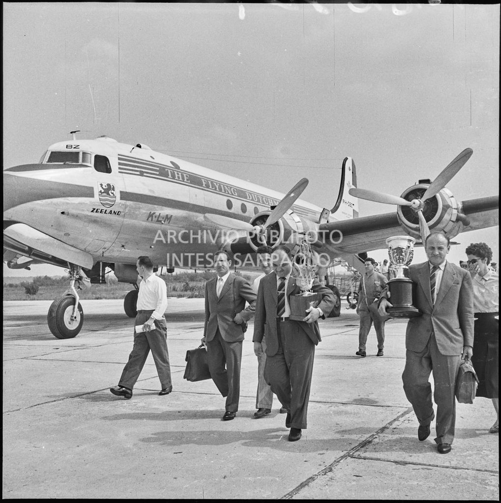 Il pilota José Froilán González (secondo da destra) sulla piata d'atterraggio dell'aeroporto di Malpensa con in mano un trofeo<br>222369