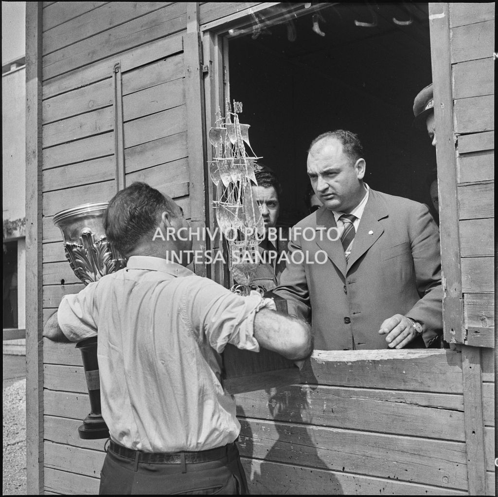 Il pilota José Froilán González affida ad un uomo il suo trofeo<br>222372