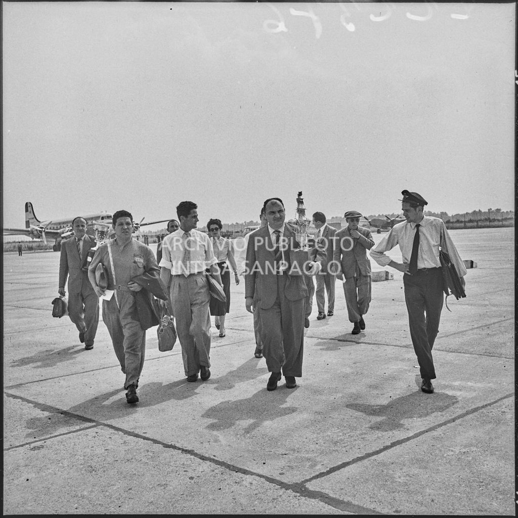 Il pilota José Froilán González sulla piata d'atterraggio dell'aeroporto di Malpensa con in mano un trofeo<br>222376