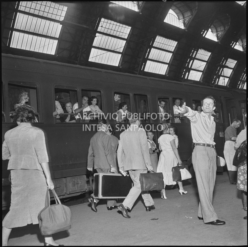 Treno in partenza e passeggeri con valige sulla banchina della stazione Centrale di Milano<br>222866