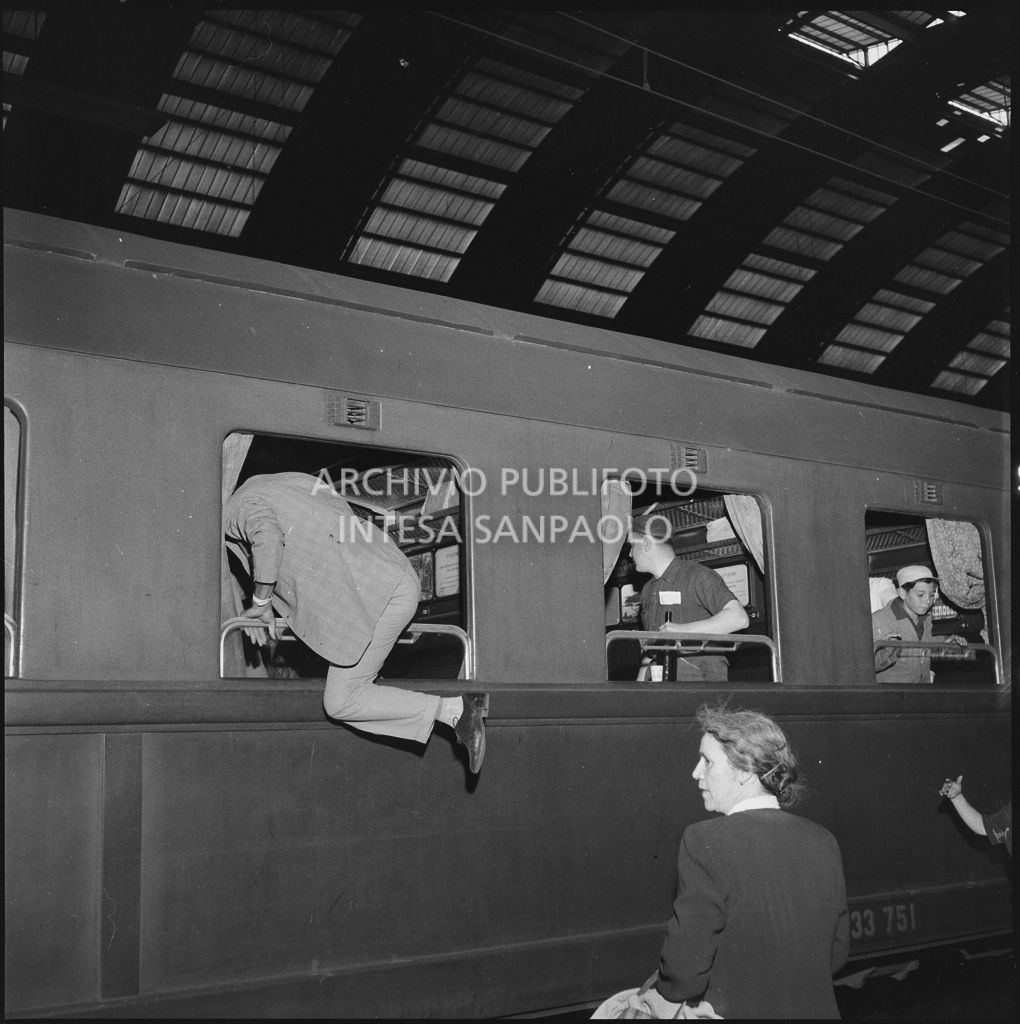 Un uomo entra dal finestrino di un treno in partenza dalla stazione Centrale di Milano<br>222869