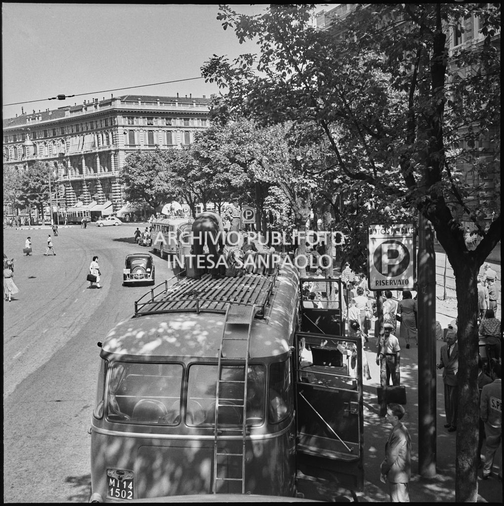 Gli autisti sistemano le valige dei passeggeri sui tetti dei pullman in partenza da piazza Castello a Milano<br>222876