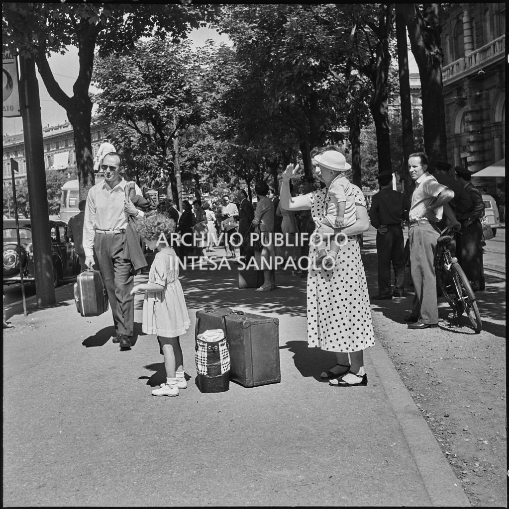 Una famiglia in attesa della partenza del pullman per le vacanze estive da piazza Castello a Milano<br>222877