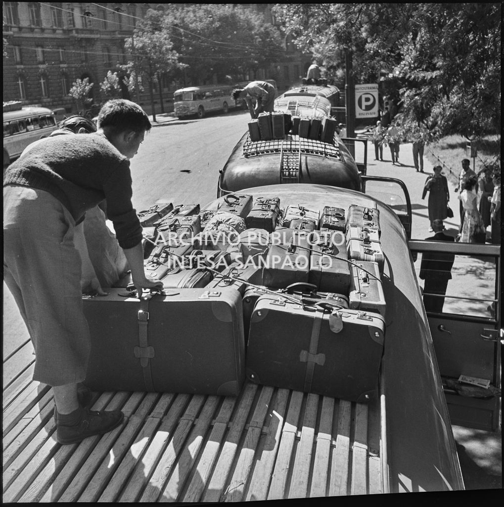 Gli autisti sistemano le valige dei passeggeri sui tetti dei pullman nei pressi del Castello Sforzesco di Milano<br>222887