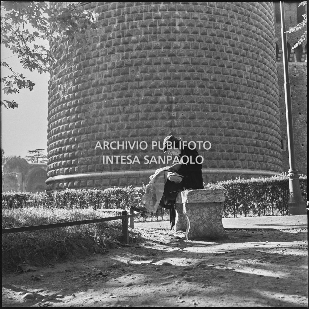 Una signora seduta su una panchina nei pressi del Castello Sforzesco di Milano<br>222890