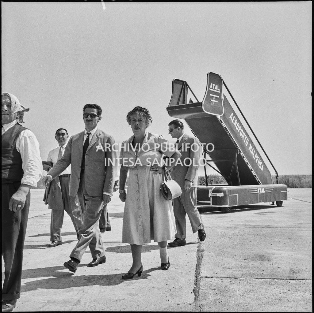 Alcune persone sulla pista d'atterraggio dell'aeroporto di Malpensa in occasione della partenza degli operai della Snia Viscosa per il Sudafrica<br>222935