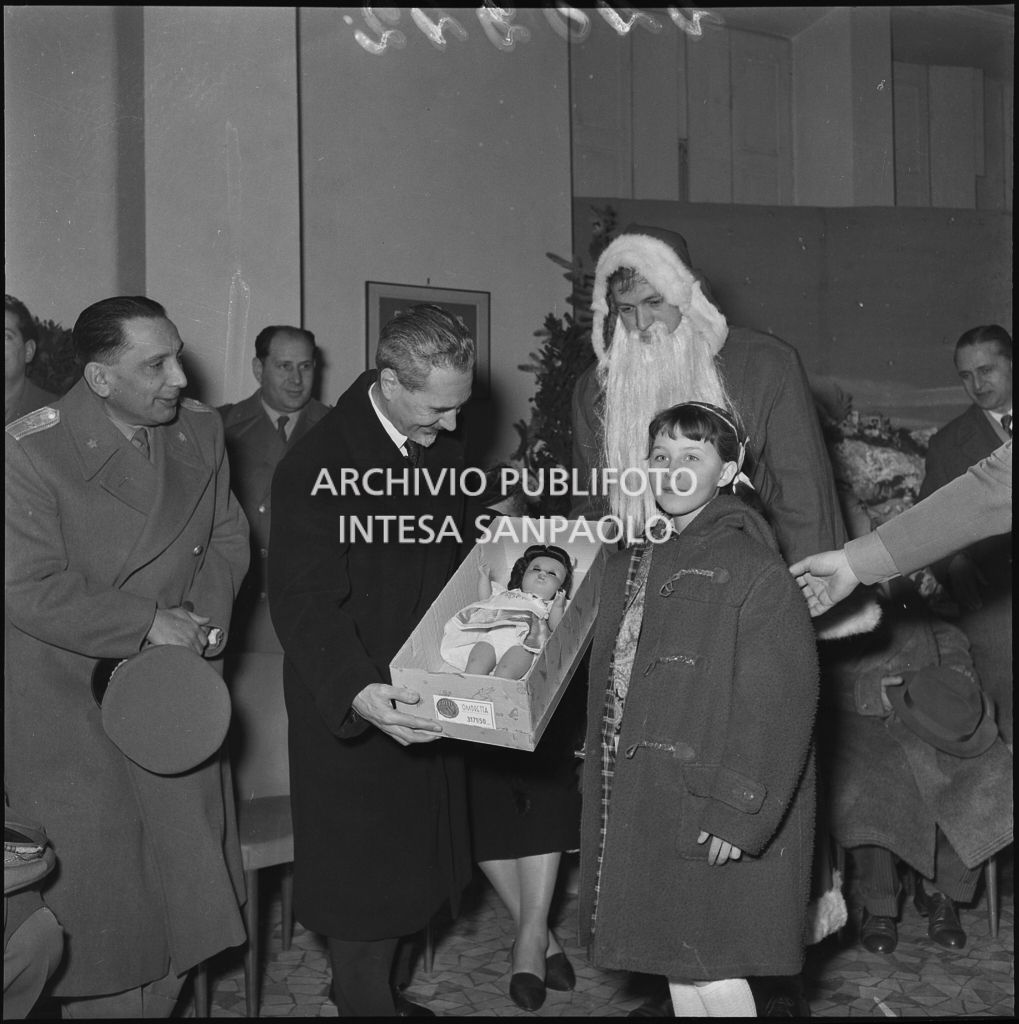 Il ministro delle Finanze Roberto Tremelloni consegna un regalo alla figlia di un finanziere nella caserma della Guardia di Finanza di via Melchiorre Gioia a Milano<br>240242