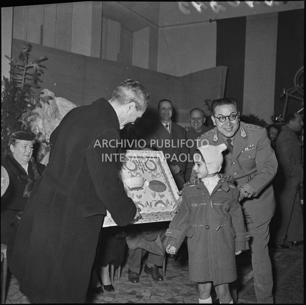 Il ministro delle Finanze Roberto Tremelloni consegna un regalo alla figlia di un finanziere nella caserma della Guardia di Finanza di via Melchiorre Gioia a Milano<br>240245