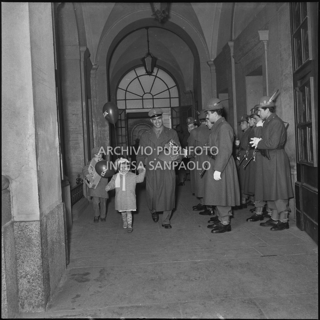 Un finanziare con i figli esce dalla caserma della Guardia di Finanza di via Melchiorre Gioia a Milano dopo la consegna dei regali<br>240259