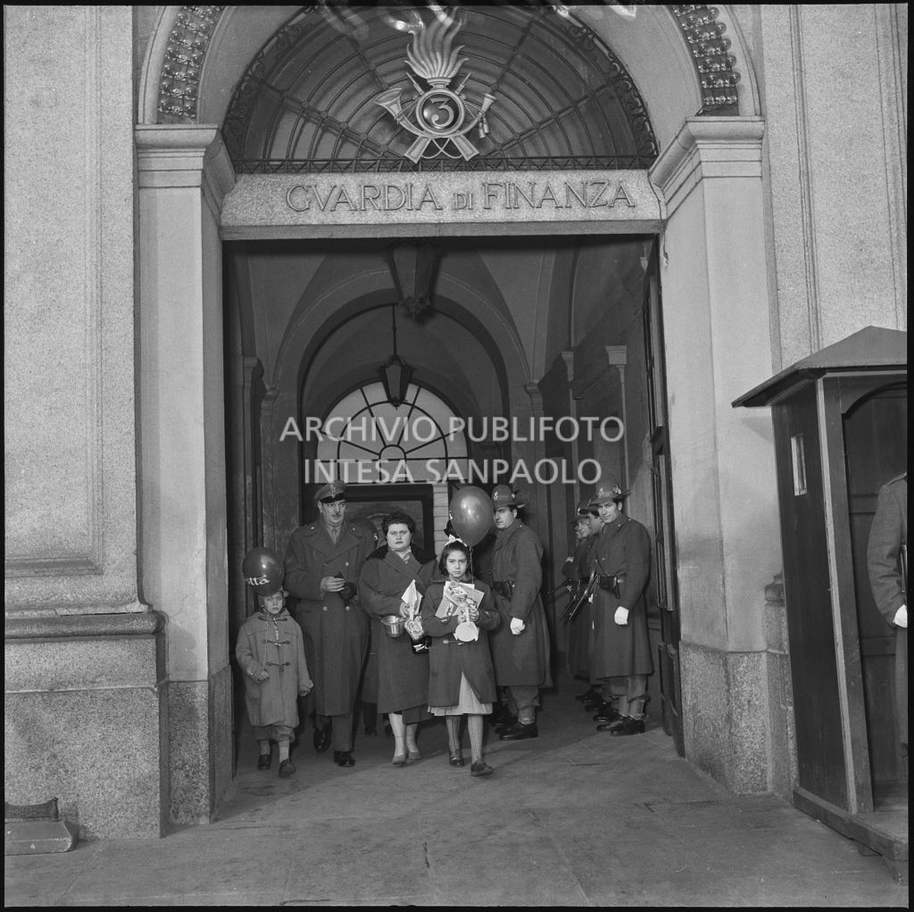 Un finanziare e la famiglia escono dalla caserma della Guardia di Finanza di via Melchiorre Gioia a Milano dopo la consegna dei regali<br>240263
