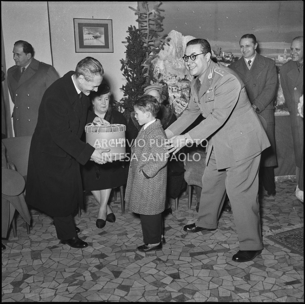 Il ministro delle Finanze Roberto Tremelloni consegna un regalo al figlio di un finanziere nella caserma della Guardia di Finanza di via Melchiorre Gioia a Milano<br>240264