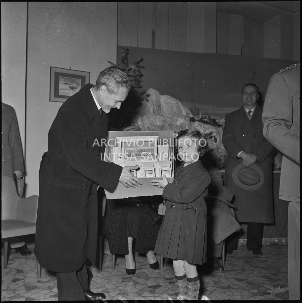 Il ministro delle Finanze Roberto Tremelloni consegna un regalo alla figlia di un finanziere nella caserma della Guardia di Finanza di via Melchiorre Gioia a Milano<br>240265