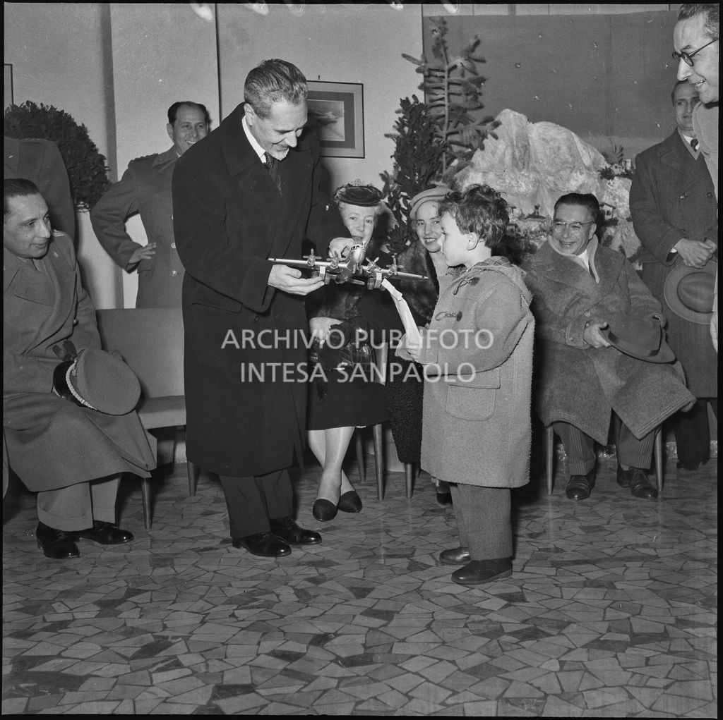 Il ministro delle Finanze Roberto Tremelloni consegna un regalo al figlio di un finanziere nella caserma della Guardia di Finanza di via Melchiorre Gioia a Milano<br>240269