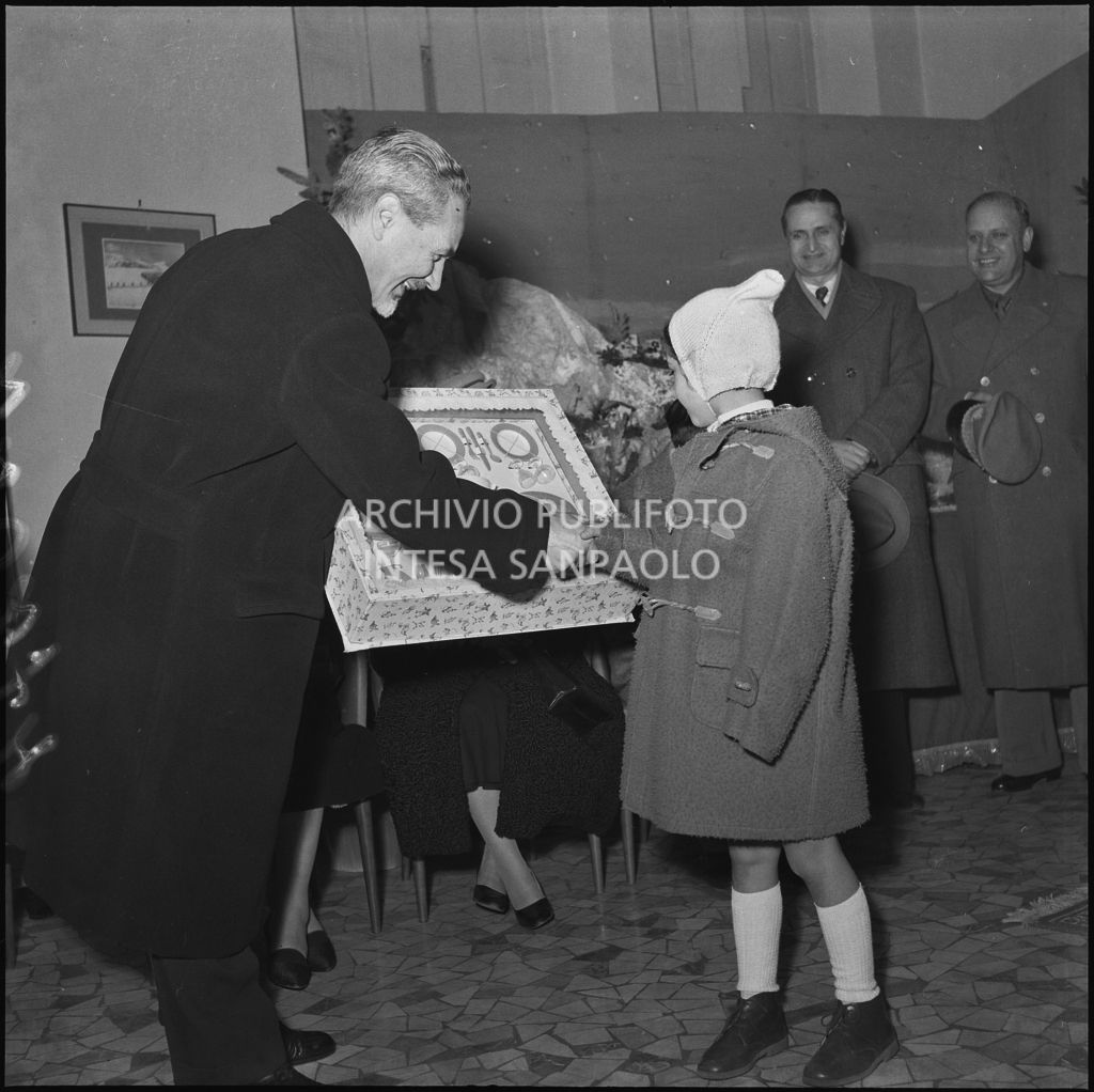 Il ministro delle Finanze Roberto Tremelloni consegna un regalo alla figlia di un finanziere nella caserma della Guardia di Finanza di via Melchiorre Gioia a Milano<br>240274