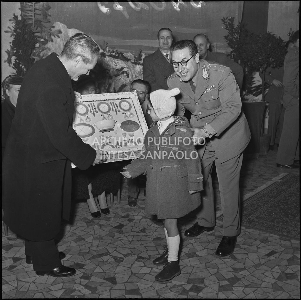 Il ministro delle Finanze Roberto Tremelloni consegna un regalo alla figlia di un finanziere nella caserma della Guardia di Finanza di via Melchiorre Gioia a Milano<br>240275