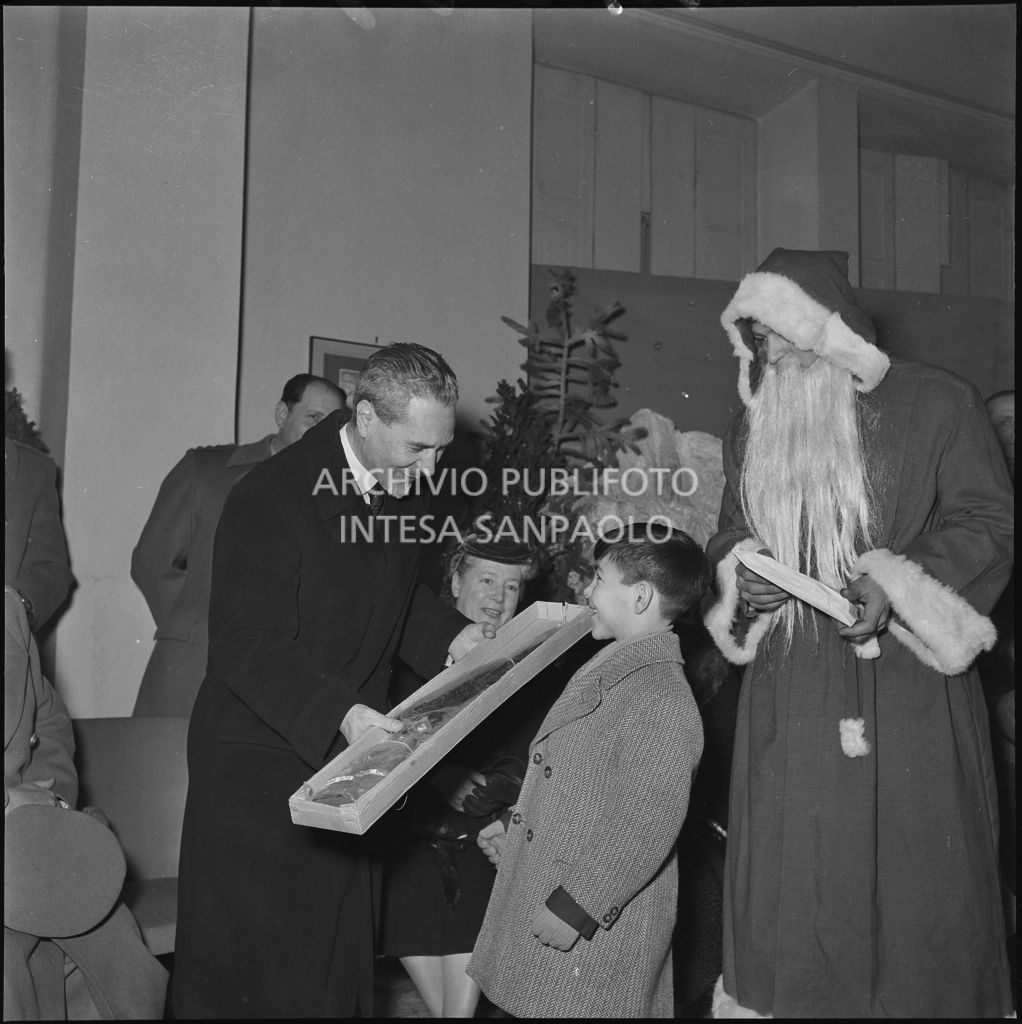 Il ministro delle Finanze Roberto Tremelloni consegna un regalo al figlio di un finanziere nella caserma della Guardia di Finanza di via Melchiorre Gioia a Milano<br>240291