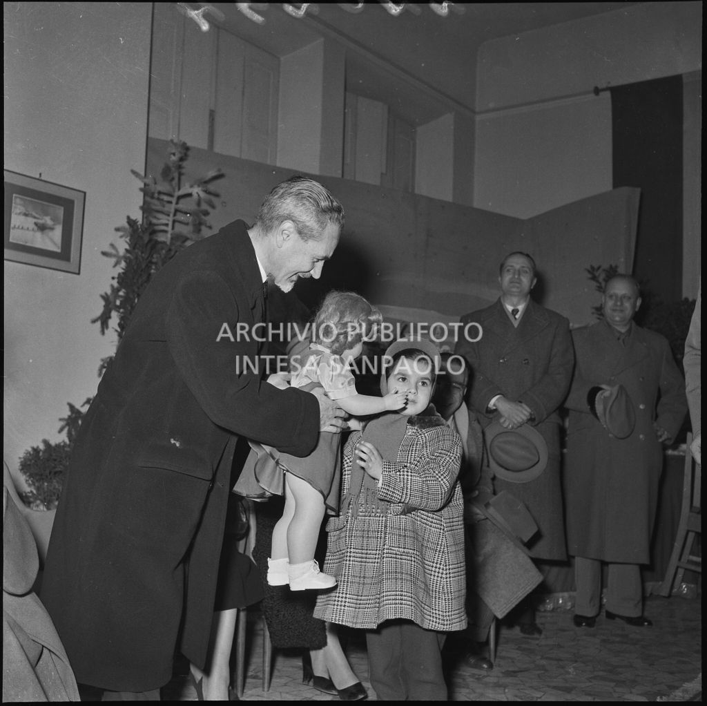 Il ministro delle Finanze Roberto Tremelloni consegna un regalo alla figlia di un finanziere nella caserma della Guardia di Finanza di via Melchiorre Gioia a Milano<br>240294