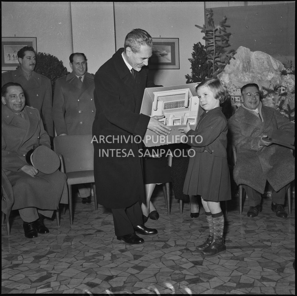 Il ministro delle Finanze Roberto Tremelloni consegna un regalo alla figlia di un finanziere nella caserma della Guardia di Finanza di via Melchiorre Gioia a Milano<br>240295