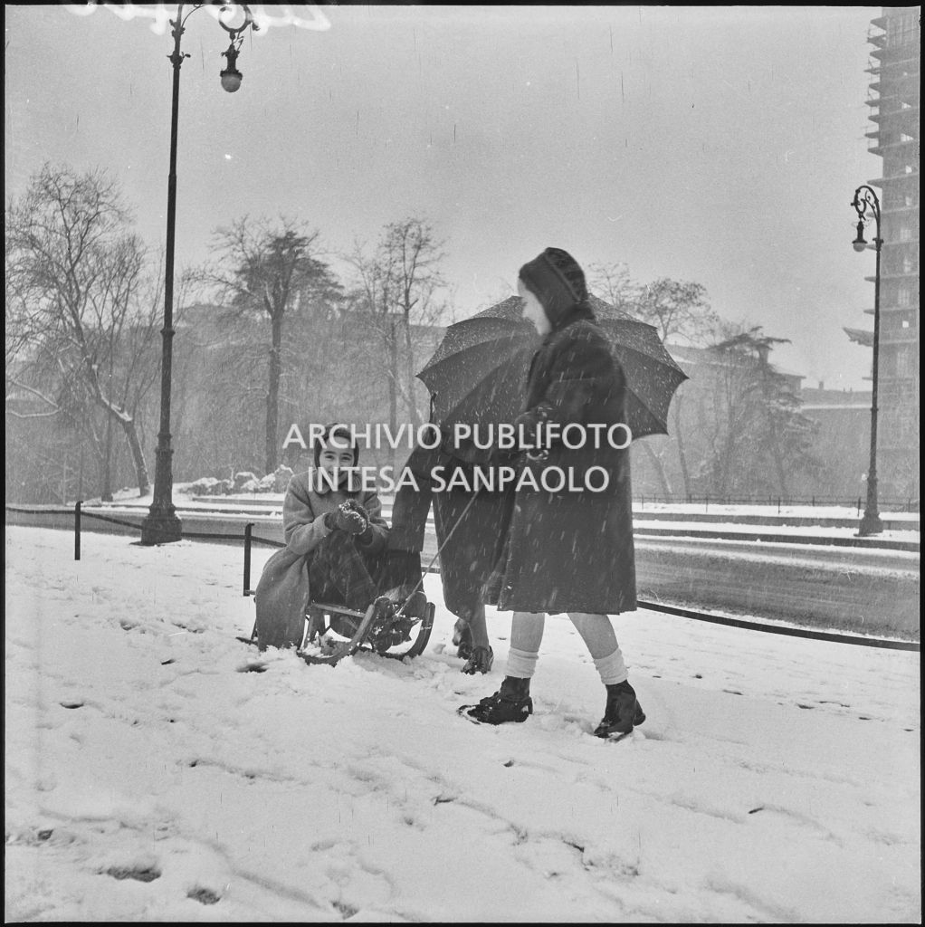 Bambine giocano con uno slittino nel parco del Castello Sforzesco di Milano<br>240410