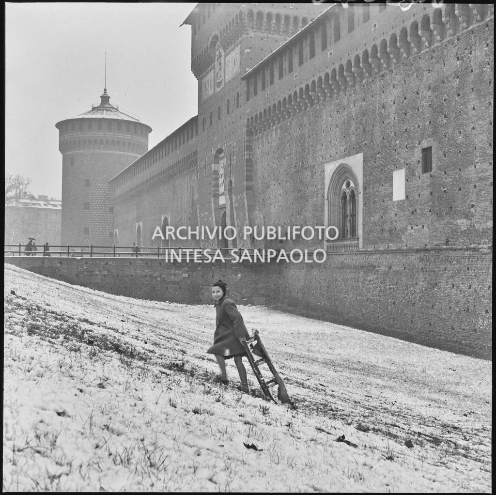 Un bambino gioca con uno slittino nel fossato esterno del Castello Sforzesco<br>240418