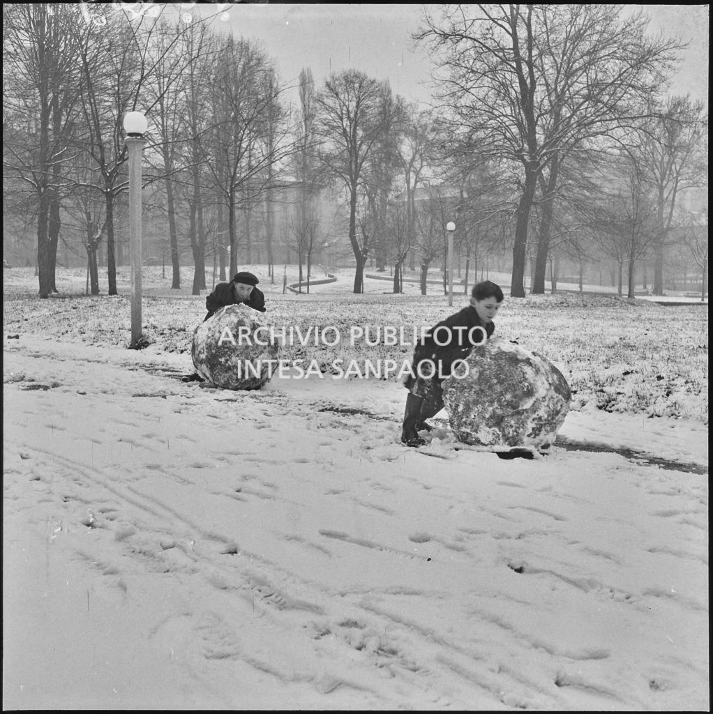 Due bambini spingono due grosse palle di neve all'esterno del Castello Sforzesco<br>240419