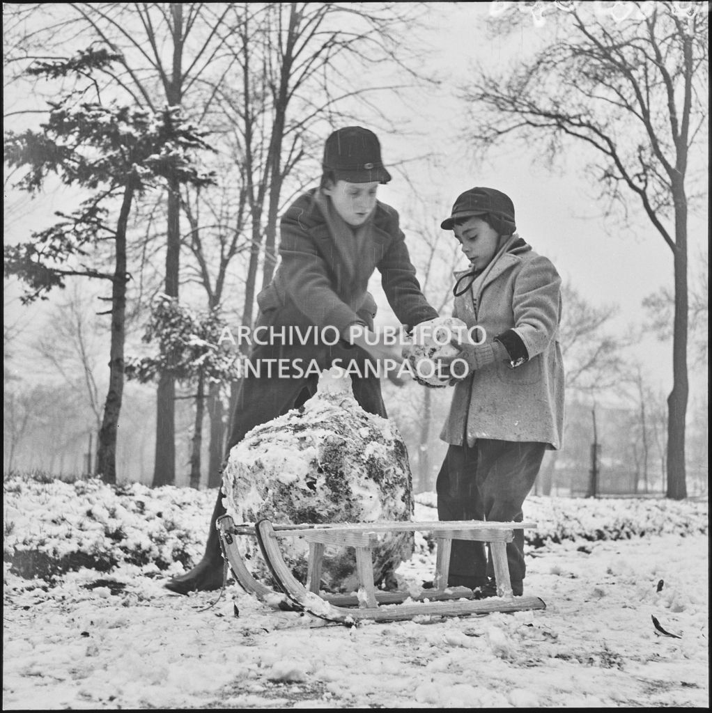 Due bambini giocano con uno slittino all'esterno del Castello Sforzesco<br>240424