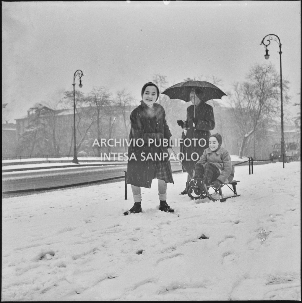 Due bambini giocano con uno slittino all'esterno del Castello Sforzesco<br>240425