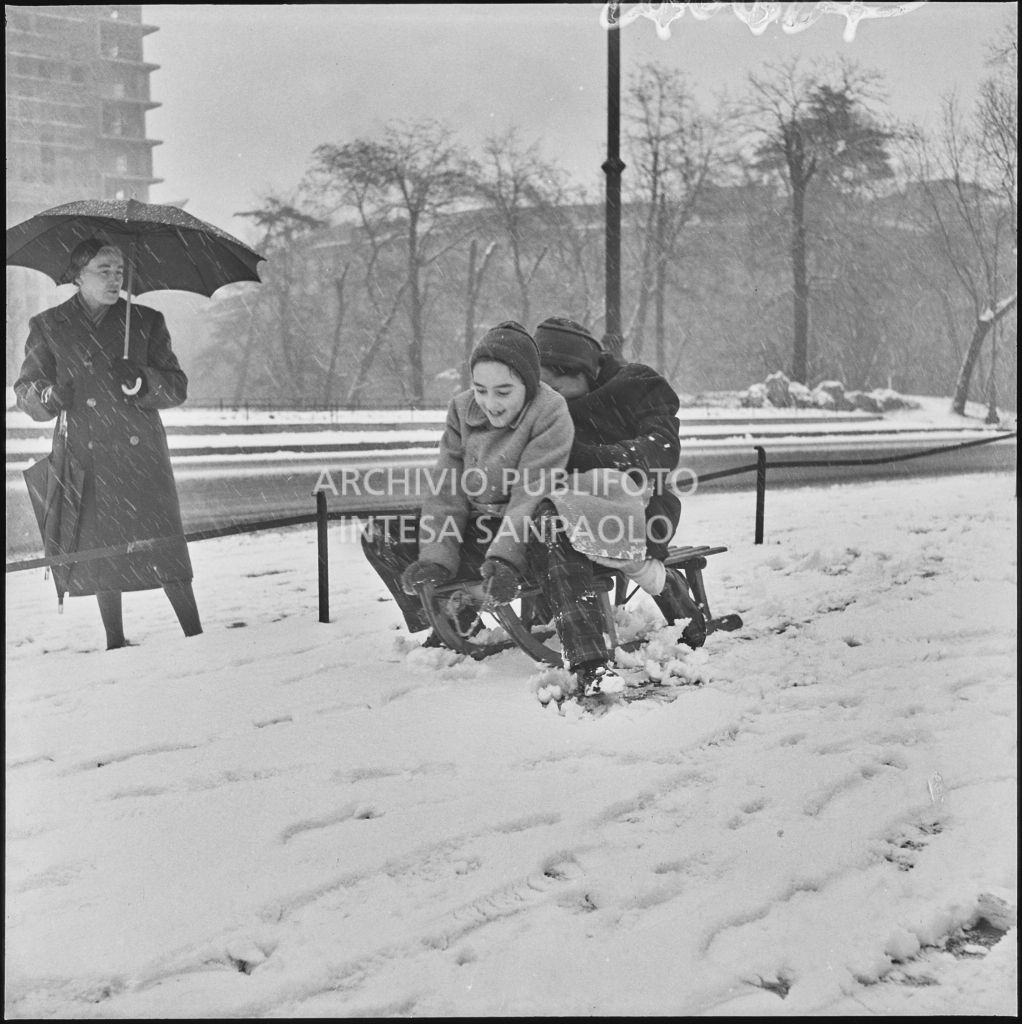 Due bambini giocano con uno slittino all'esterno del Castello Sforzesco<br>240427