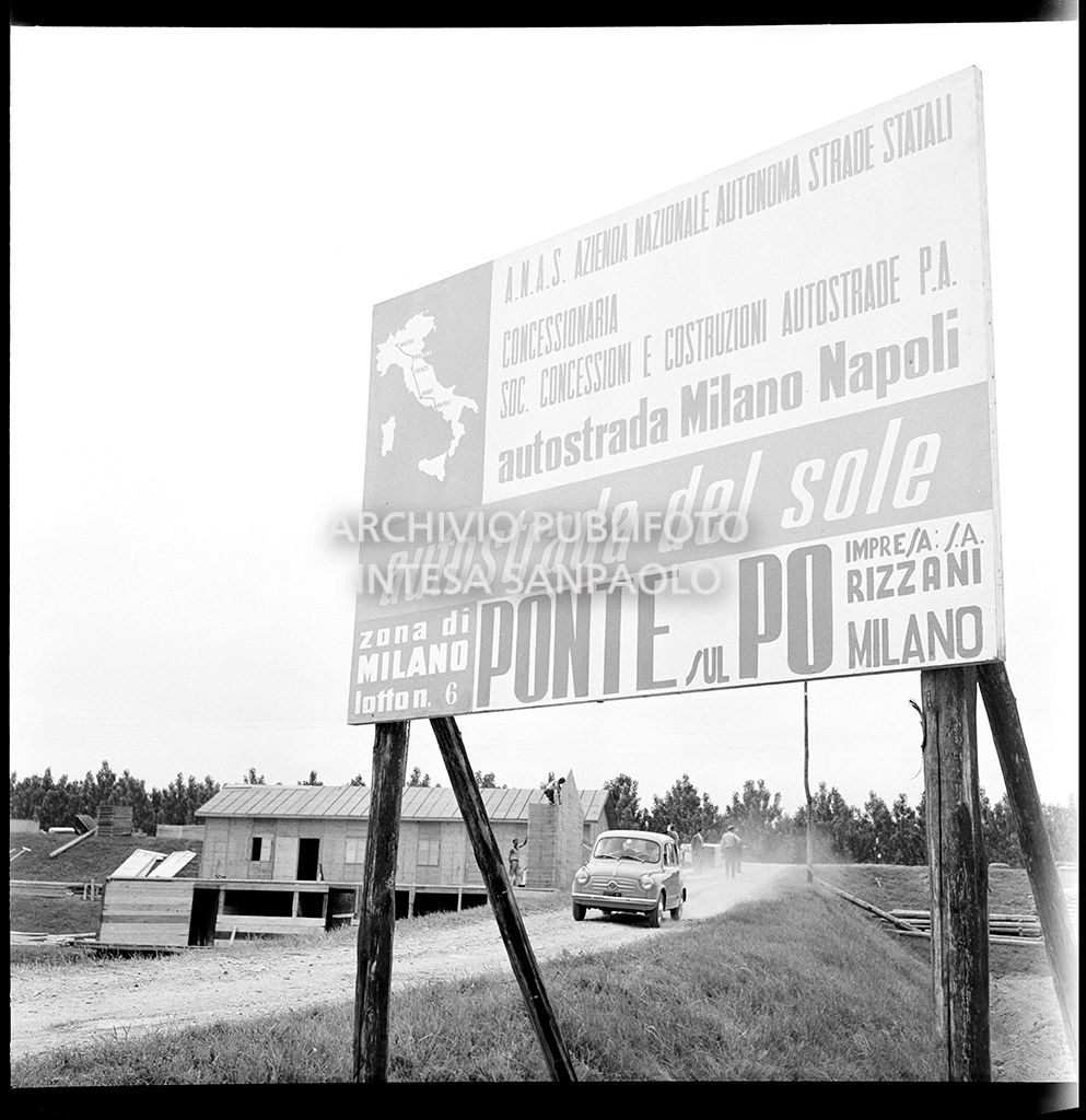 Cartello che segnala il cantiere per la costruzione del ponte dell'Autostrada del Sole, sul fiume Po, nei pressi di Mortizza