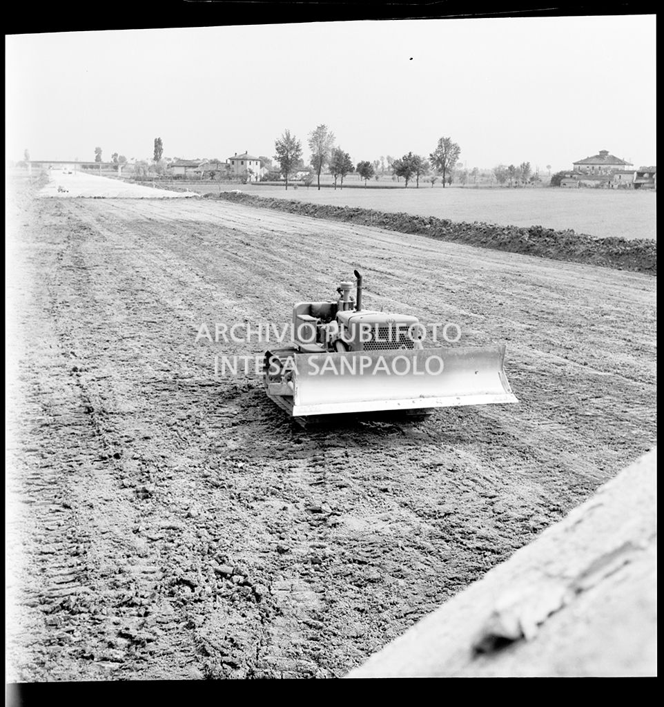 Una ruspa nel cantiere per la costruzione dell'Autostrada del Sole nel tratto Piacenza-Pontenure<br>383251