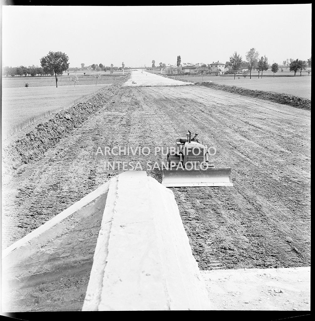 Una ruspa nel cantiere per la costruzione dell'Autostrada del Sole nel tratto Piacenza-Pontenure<br>383252