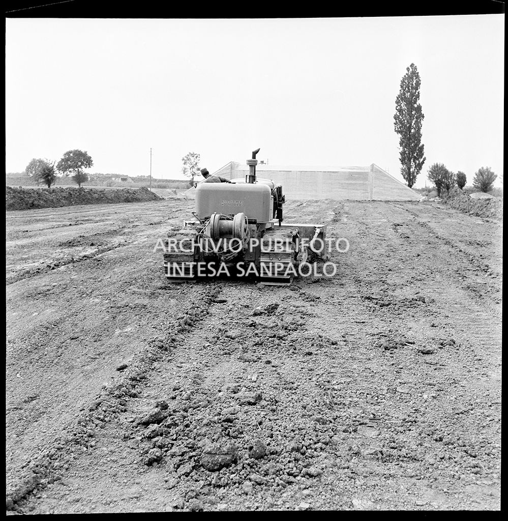 Una ruspa nel cantiere per la costruzione dell'Autostrada del Sole nel tratto Piacenza-Pontenure<br>383253
