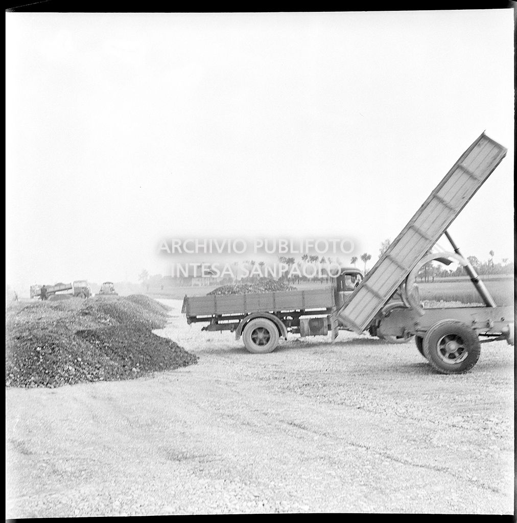 Scarico materiale nel cantiere per la costruzione dell'Autostrada del Sole nel tratto Piacenza-Pontenure<br>383258