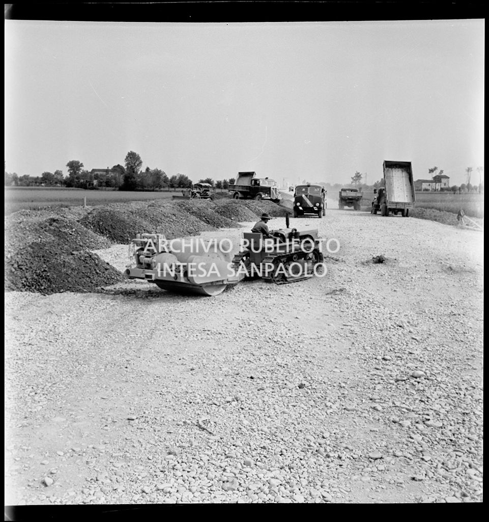Schiacciasassi e autocarri nel cantiere di costruzione dell'Autostrada del Sole nei pressi di Pontenure<br>383267