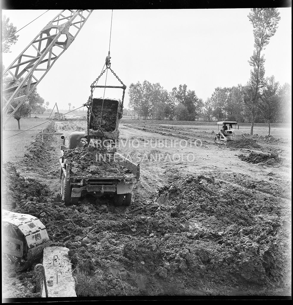 Scarico escavatrice nel cantiere di costruzione dell'Autostrada del Sole nei pressi di Fontanellato, tratto Fidenza-Parma<br>383280