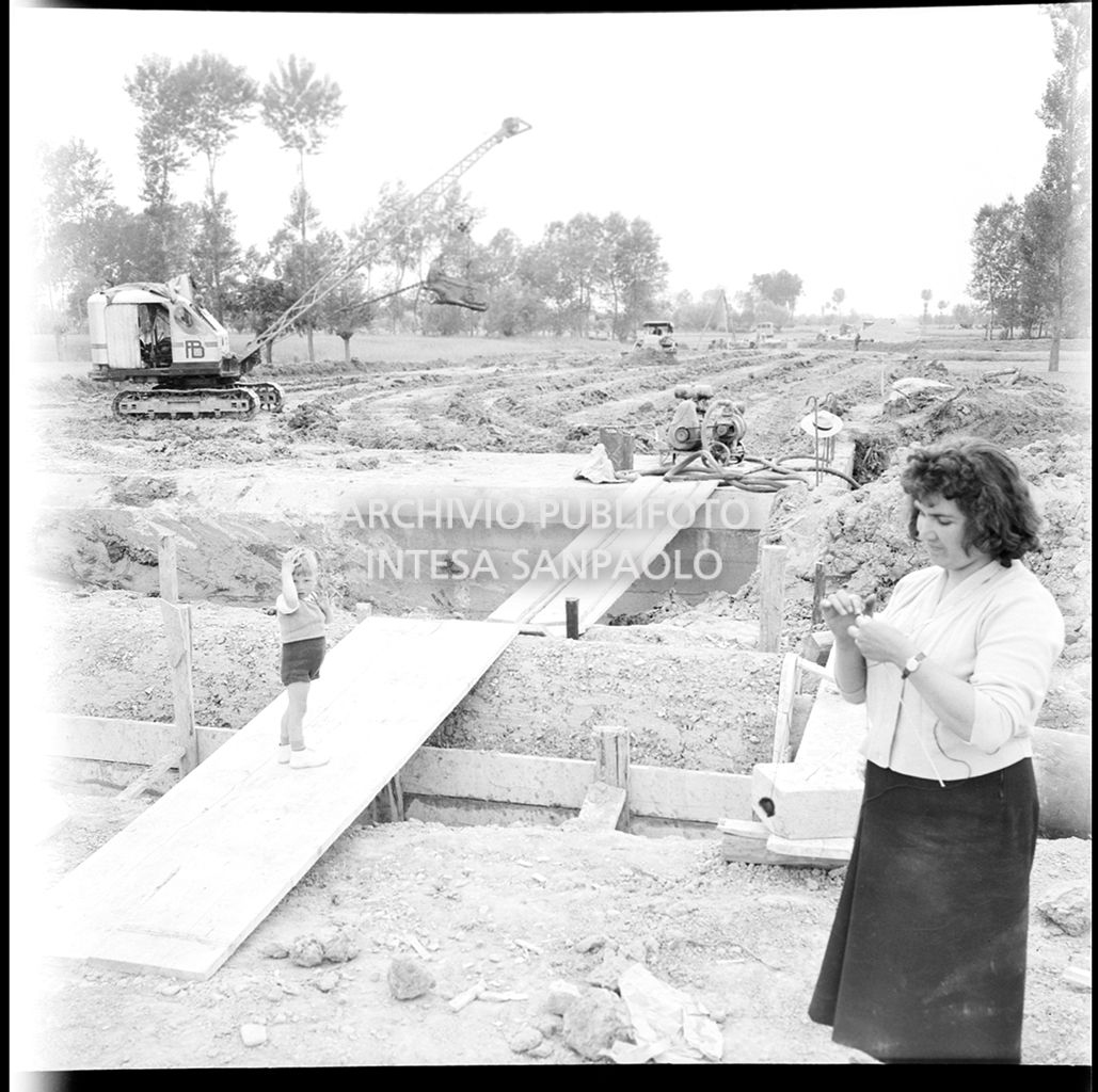 Un donna e un bambino nel cantiere di costruzione dell'Autostrada del Sole nei pressi di Fontanellato, tratto Fidenza-Parma<br>383283