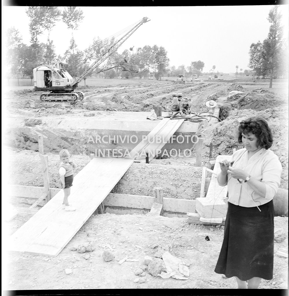 Un donna e un bambino nel cantiere di costruzione dell'Autostrada del Sole nei pressi di Fontanellato, tratto Fidenza-Parma<br>383284